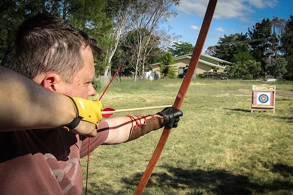 Man drawing a bow and arrow