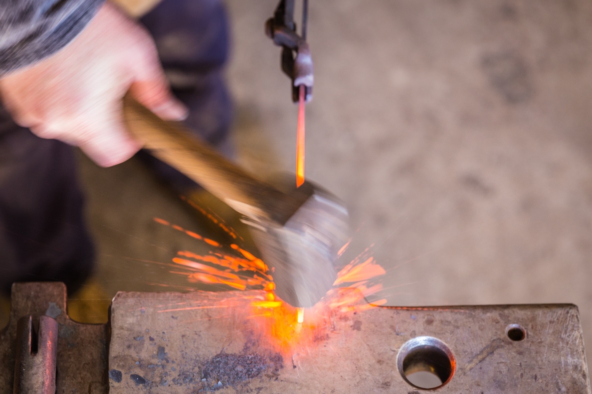 Hammer striking hot steel and making sparks at Tharwa Valley Forge