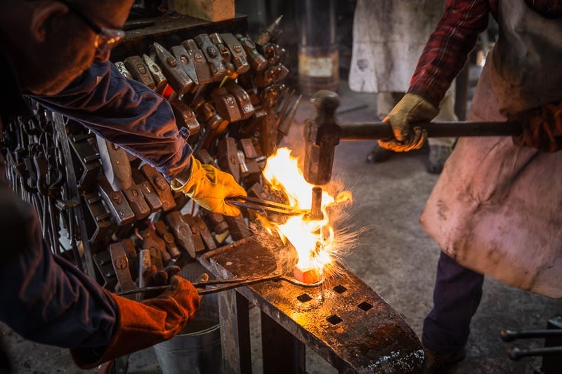 blacksmith and striker forging a hammer head